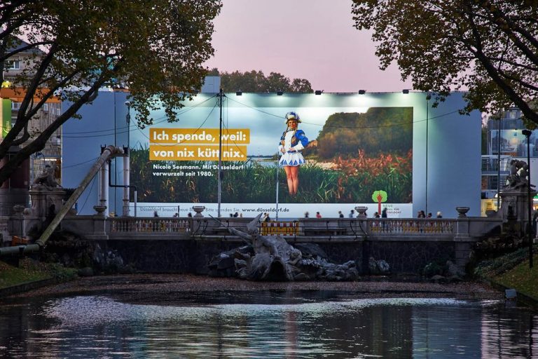 Riesenposter wirbt für Baumspende in Düsseldorf